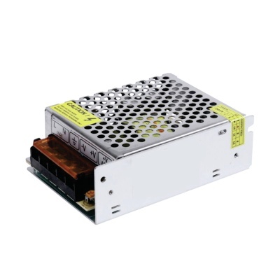 Fonte de alimentação metálica prateada perfurada com terminais pretos e etiquetas amarelas