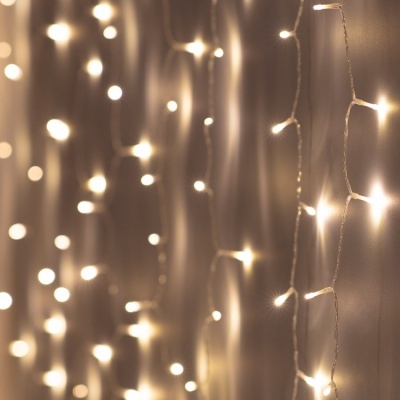 Cordões de luzes LED brancas quentes penduradas contra parede