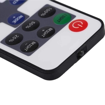 Comando remoto branco e preto com botões coloridos e texto em inglês