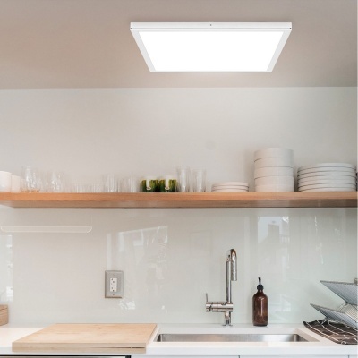 Luz de teto quadrada branca LED numa cozinha moderna branca com prateleira de madeira e utensílios.