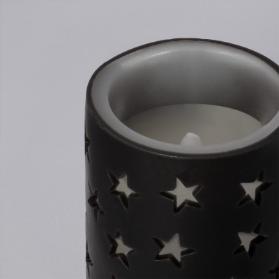 Vela branca em castiçal preto com estrelas recortadas