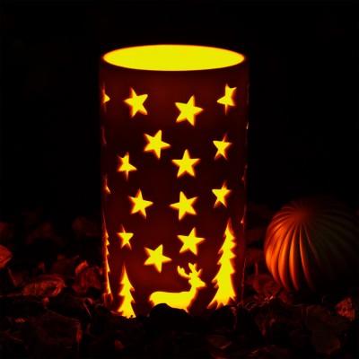 Lanterna cilíndrica branca com recortes de estrelas, pinheiros e rena iluminada por dentro