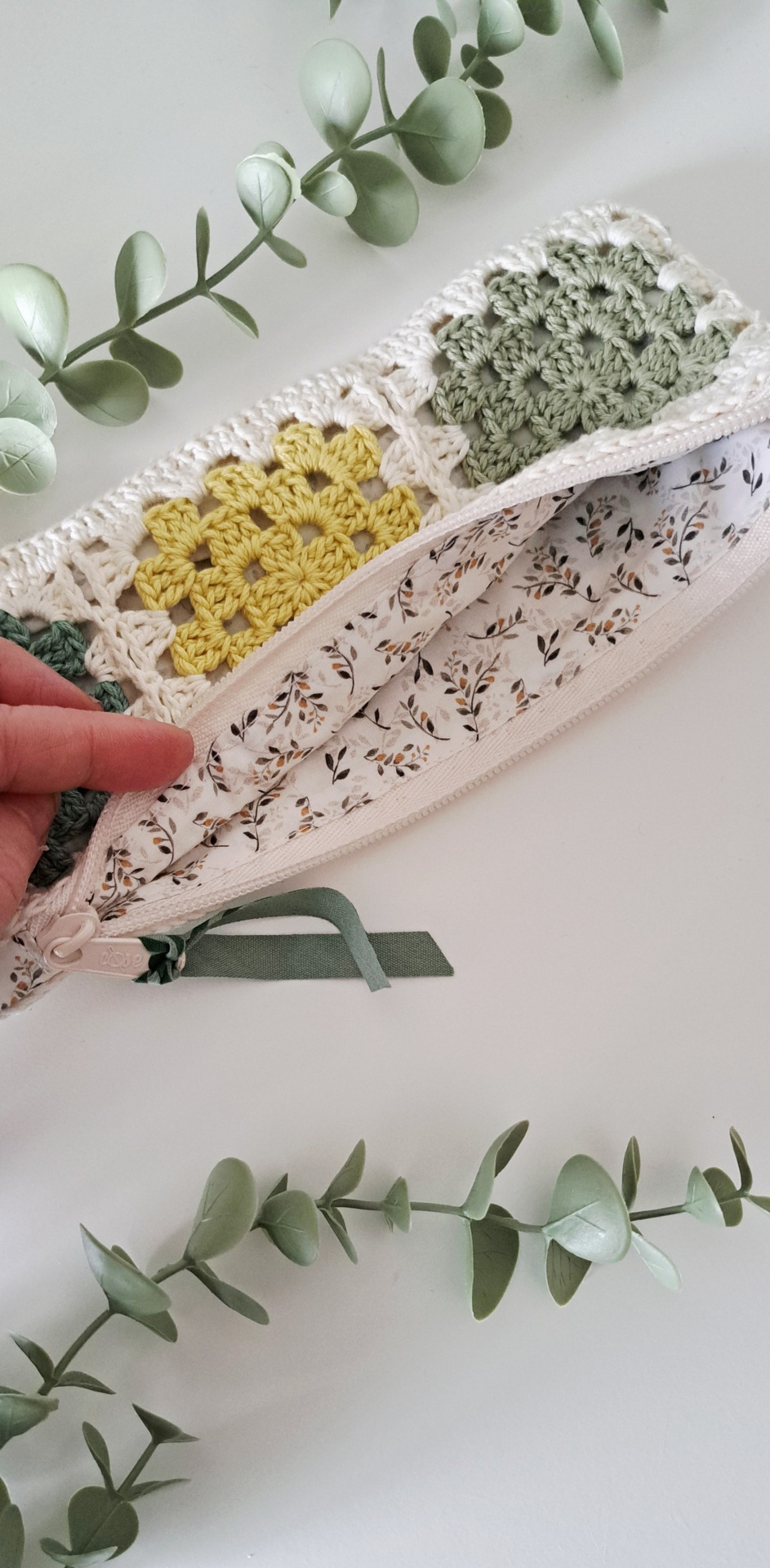 Estojo Granny squares ♥ Estojo aberto em croché com padrão colorido e forro com padrão de folhas, com ramo verde ao lado