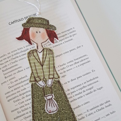 Marcador de livros tecido figura feminina verde cabelo ruivo sobre livro texto português