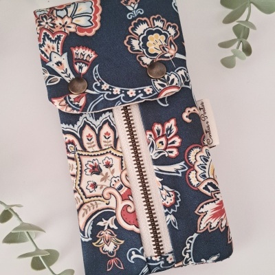 Estojo de tecido floral em azul, branco, rosa e vermelho com fecho frontal e tampa com fecho de pressão