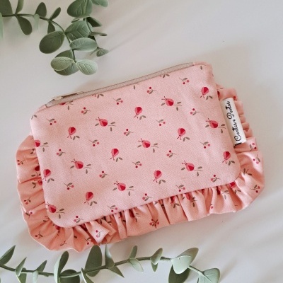 Estojo tecido cor-de-rosa com padrão floral e folhos