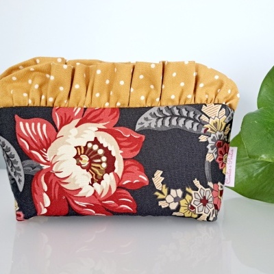 Necessaire floral com parte superior mostarda com bolinhas brancas e fundo preto