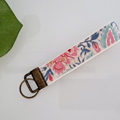 Chaveiro de tecido floral com argola metálica bronze e detalhe em couro castanho