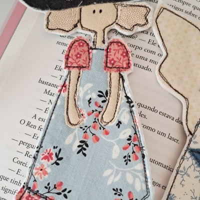 Marcador de livro de tecido em forma de mulher com vestido azul e chapéu preto