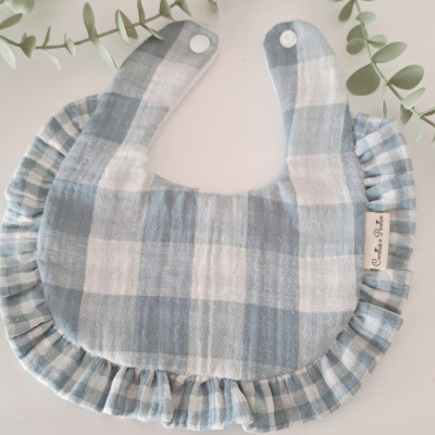 Babete de bebé azul e branco xadrez com folhos e fecho de plástico