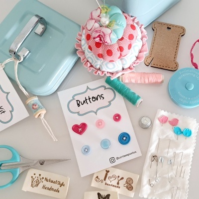 Kit de costura com máquina azul, botões, alfineteiro cupcake e acessórios