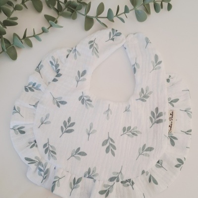 Babete branco com padrão de folhas verdes e folhos