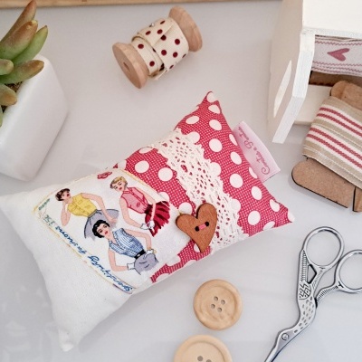 Alfineteiro retangular decorado com tecido branco e rosa, renda e botão coração, com tesoura e botões ao lado