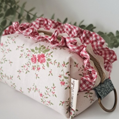 Bolsa retangular de tecido floral com folho xadrez vermelho e branco e fecho de correr dourado