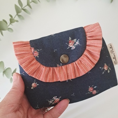 Carteira azul com flores e folho laranja com botão metálico