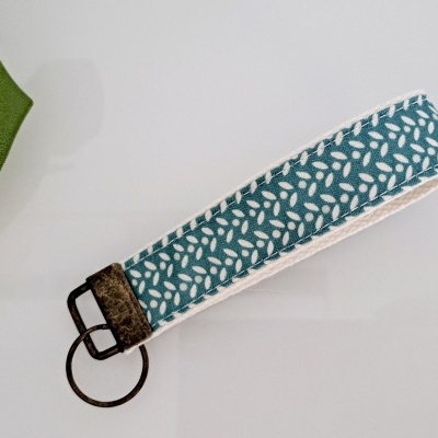 Chaveiro de tecido azul com padrão branco e argola metálica escura