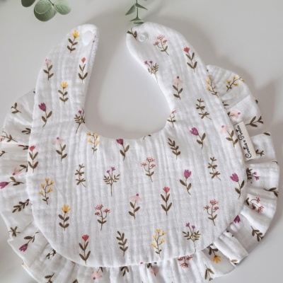 Babete branco com padrão de flores coloridas e acabamento franzido