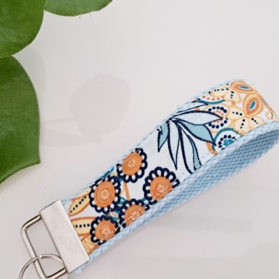 Pulseira ou porta-chaves de tecido com padrão floral laranja, azul e amarelo