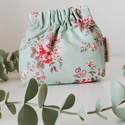 Bolsa pequena de tecido floral azul claro com elástico na abertura