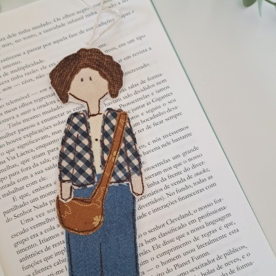 Marcador de livros tecido figura masculina xadrez calças ganga mochila castanha livro aberto