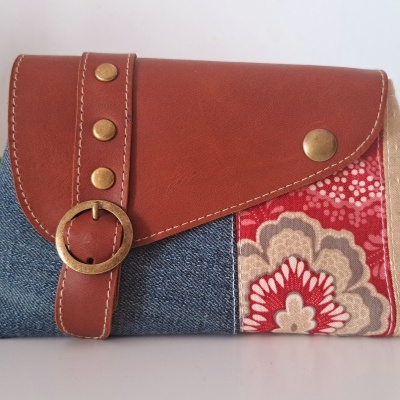 Necessaire jeans, tecido estampado floral vermelho, detalhe couro marrom com botões e fivela