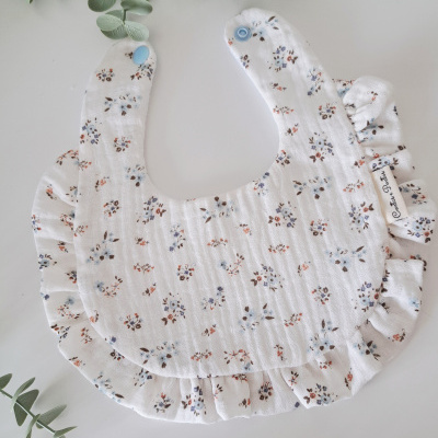 Babete de bebé branco com flores pequenas e folhos