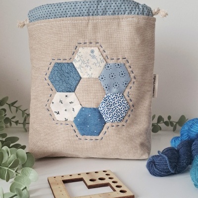 Saco de tecido bege com patchwork azul e acessórios de lã