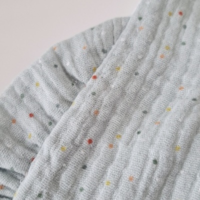 Tecido cinza claro com pontos coloridos e textura enrugada