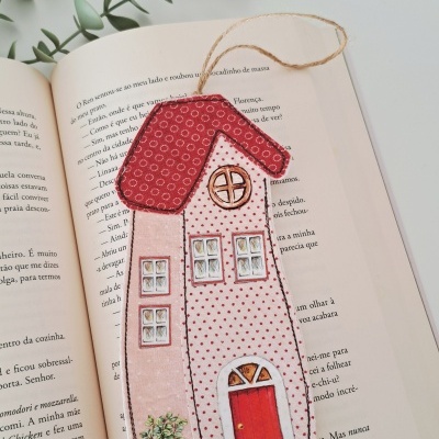 Marcador de livros em tecido em forma de casa com telhado vermelho e janelas desenhadas