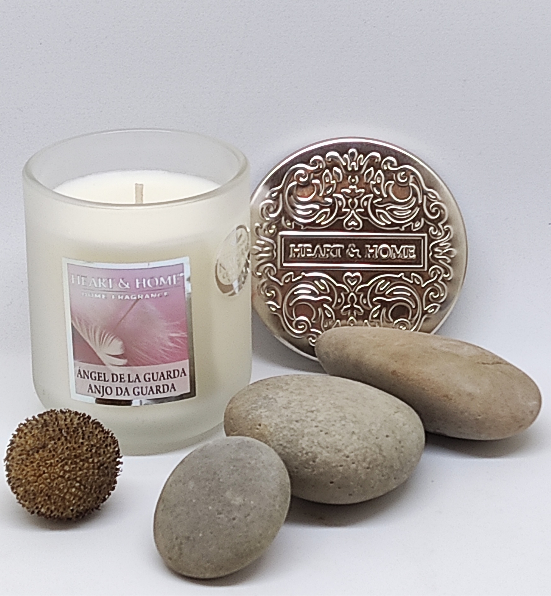 Vela perfumada com etiqueta e pedras em fundo branco