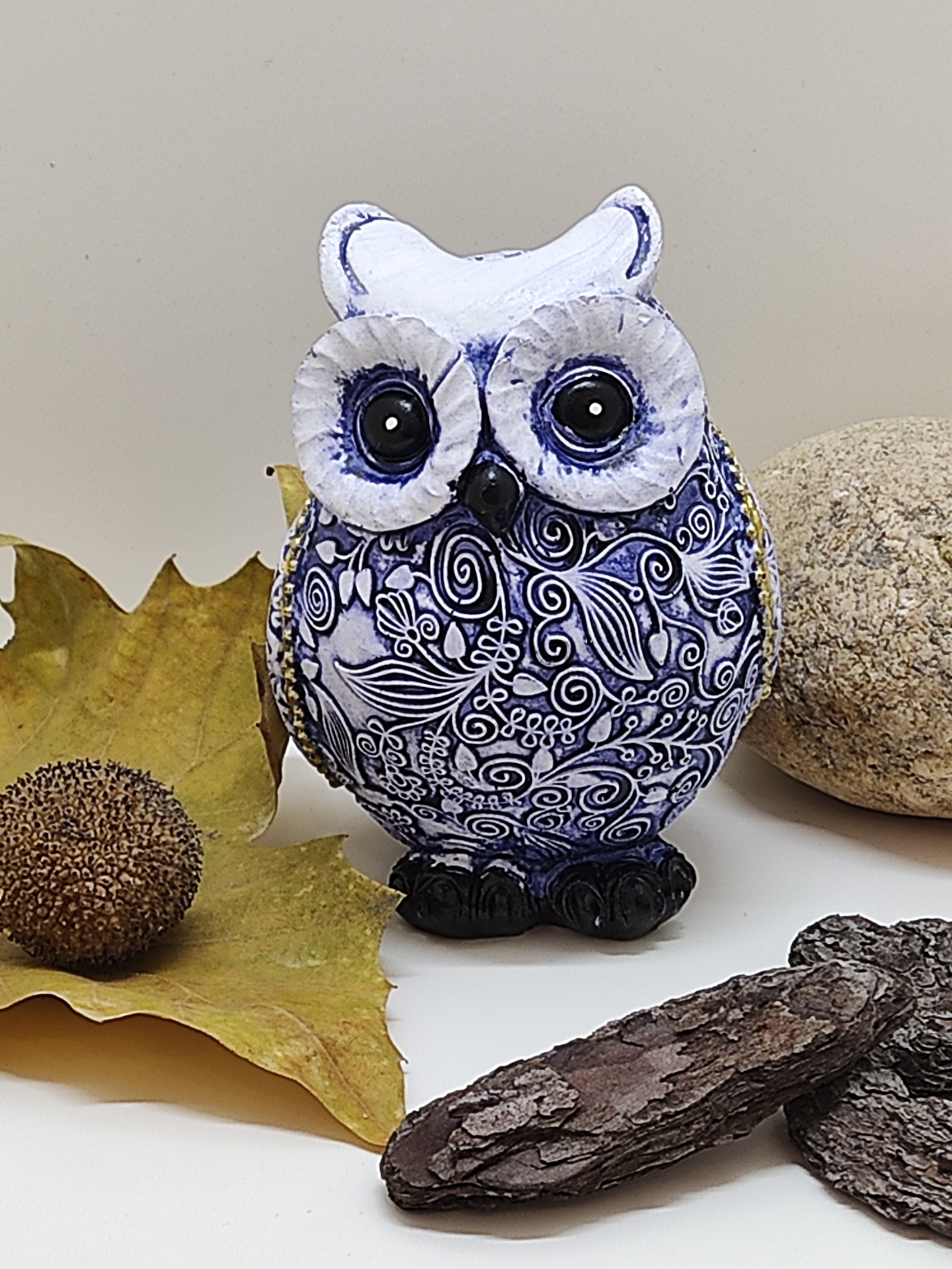 Peça decorativa de cerâmica coruja azul e branca com olhos pretos grandes