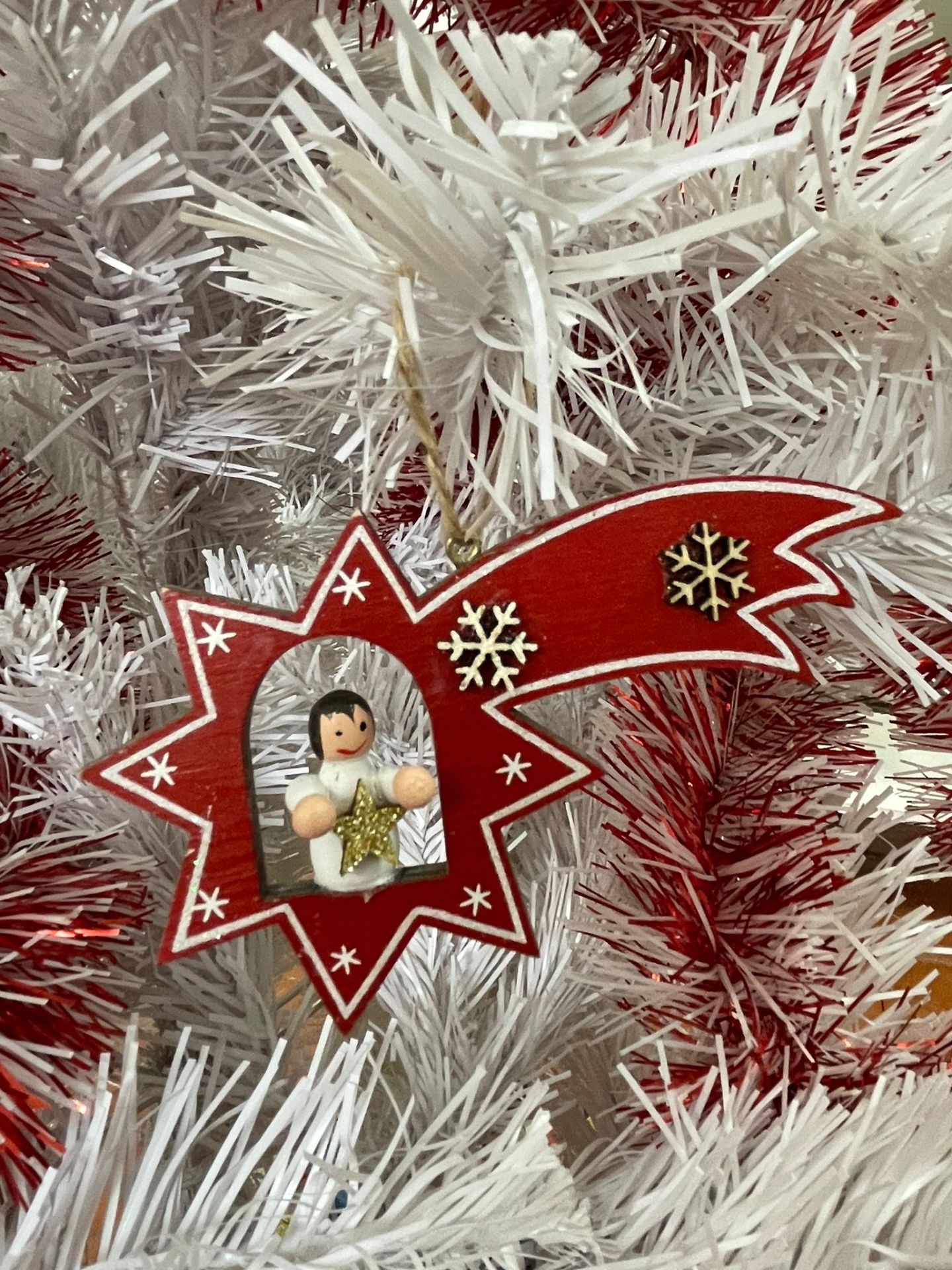 Enfeite de Natal de madeira vermelha com anjo pendurado em árvore branca