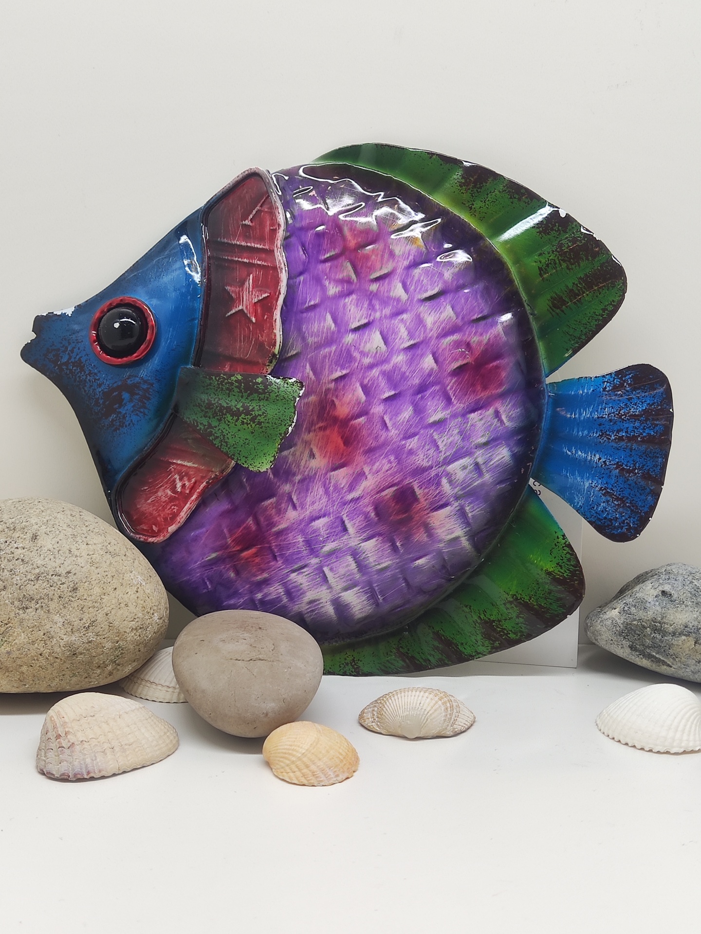 Peixe decorativo colorido em metal com pedras e conchas