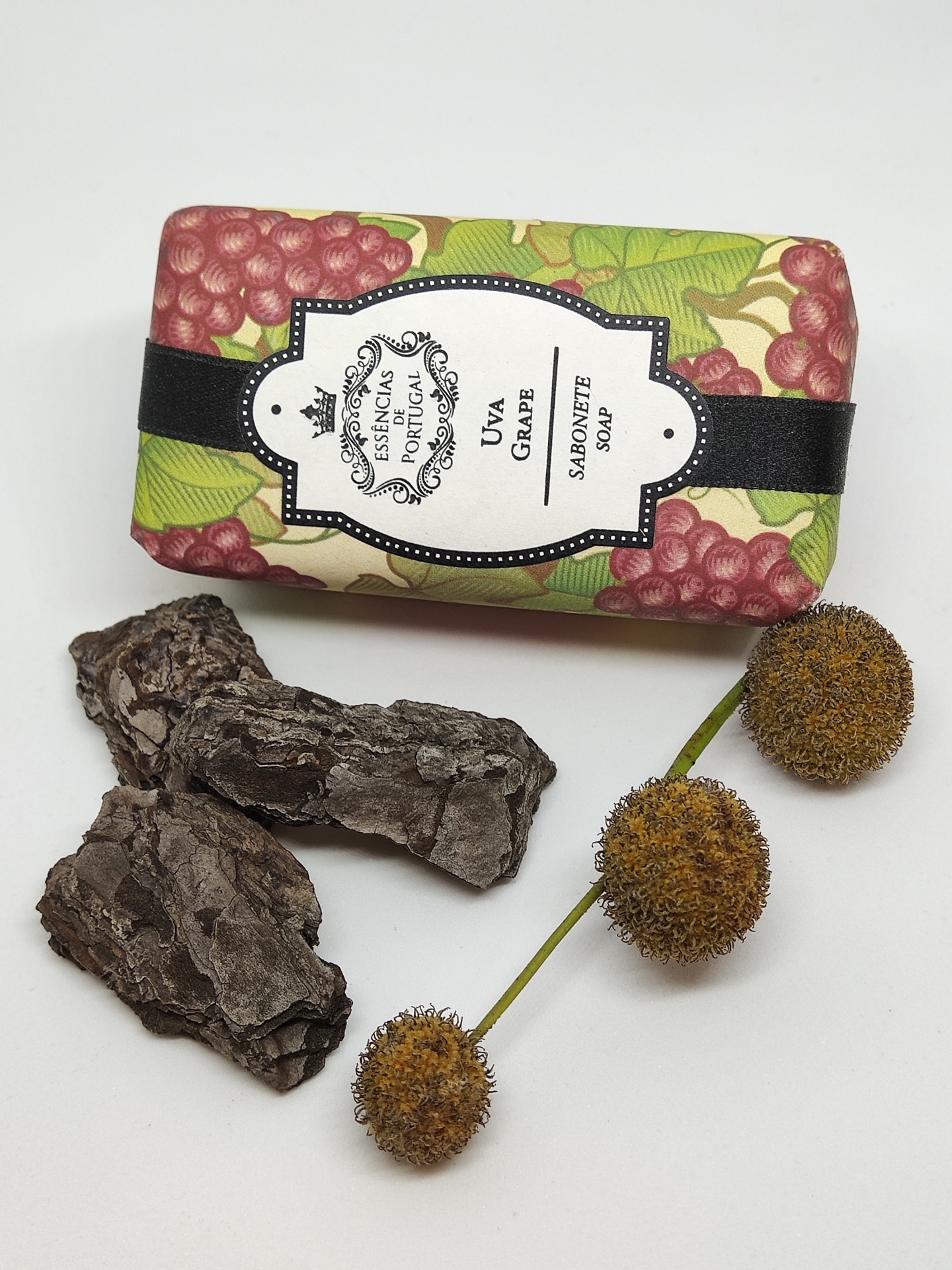 Sabonete com embalagem decorada com uvas, casca de árvore e flores secas.