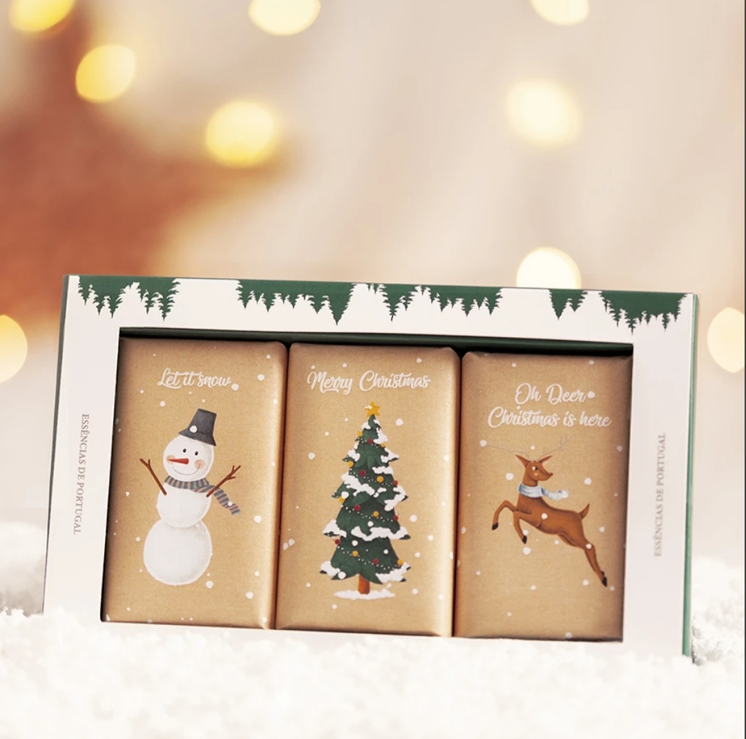 Três barras de chocolate com decoração natalícia e texto em inglês numa caixa branca