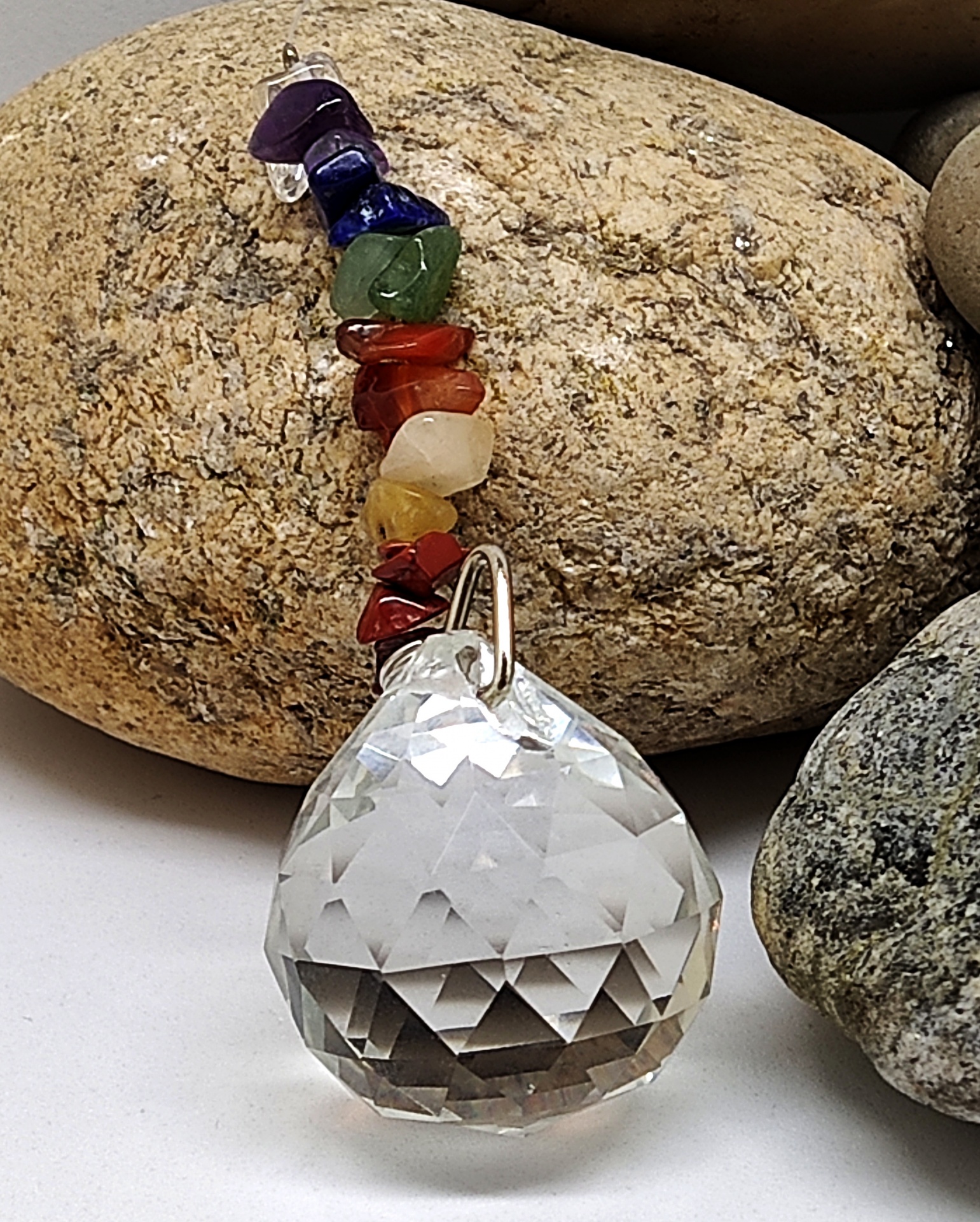 Pendente com pedra facetada e pedras coloridas sobre pedras naturais