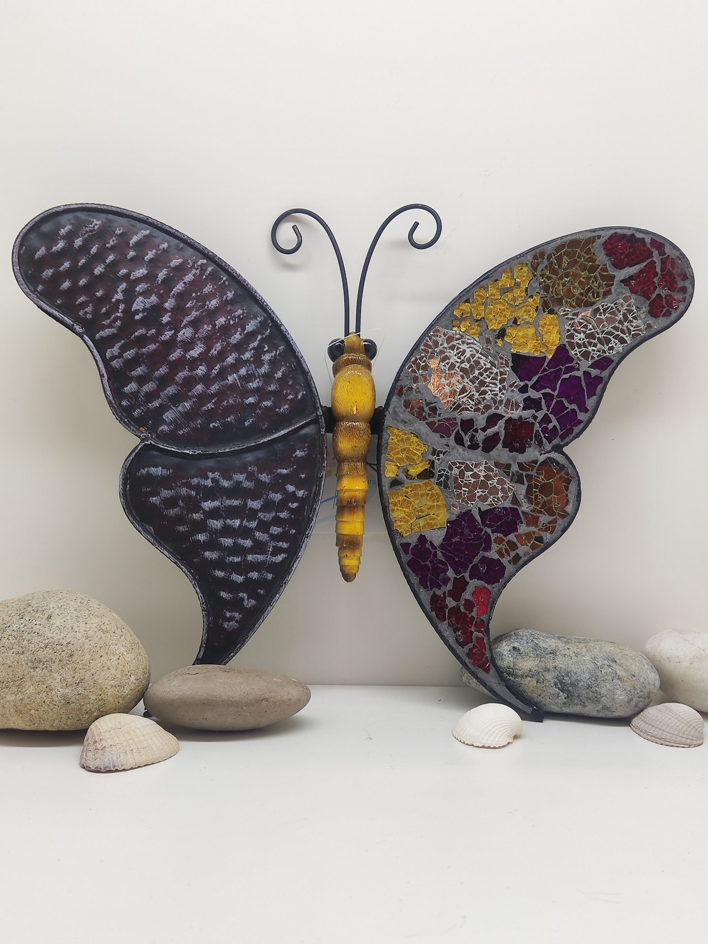 Escultura decorativa de borboleta com asas coloridas em mosaico