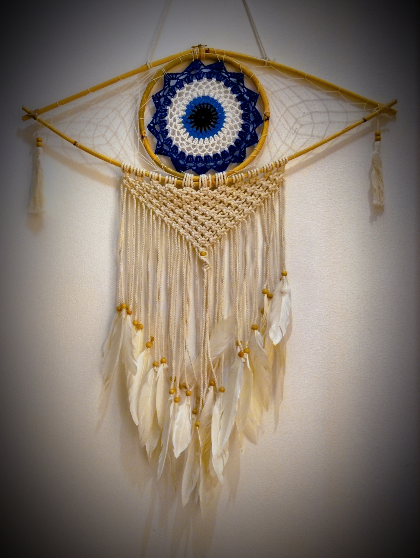 Apanhador de sonhos de fios e penas com estrutura de madeira em formas circular e quadrada