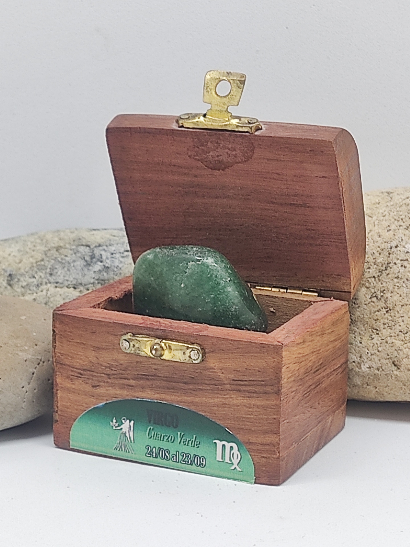 Caixa de madeira com pedra verde e etiqueta com texto Cuarzo Verde e datas