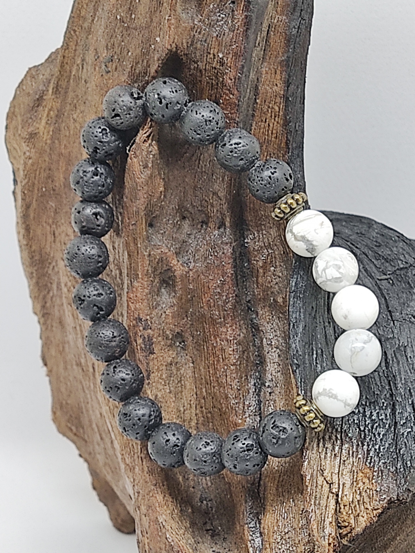 Pulseira de bolas pretas e brancas sobre madeira rústica