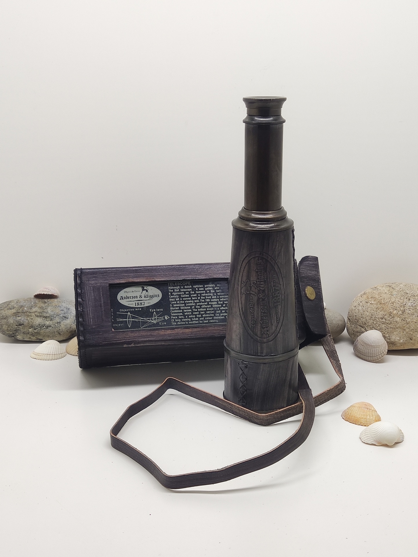 Telescópio de madeira escura com estojo e conchas ao redor