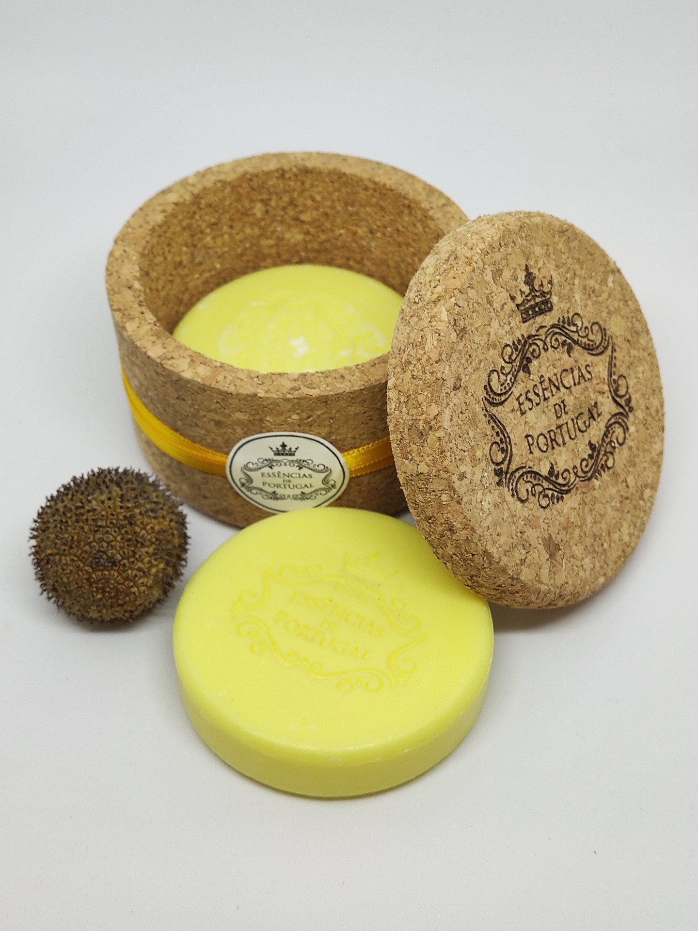 Caixa redonda de cortiça com sabonete amarelo e bola espinhosa