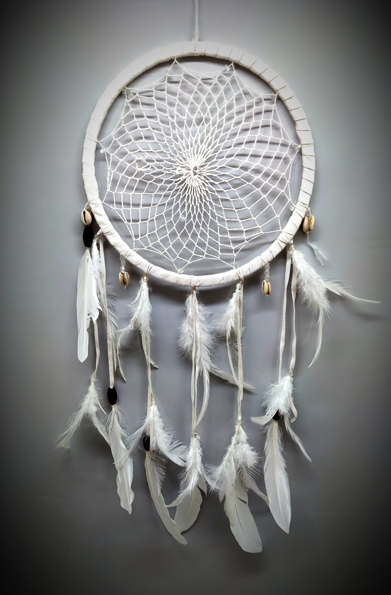 Apanhador de sonhos branco com penas e contas naturais penduradas