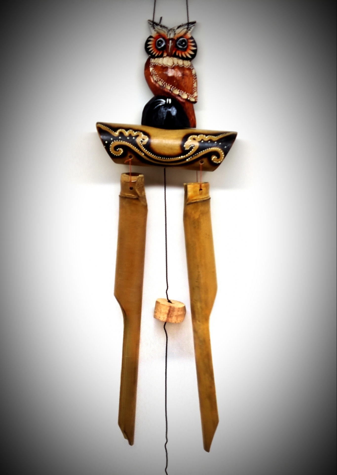 Mobil decorativo de parede com coruja esculpida e elementos pendurados em madeira 