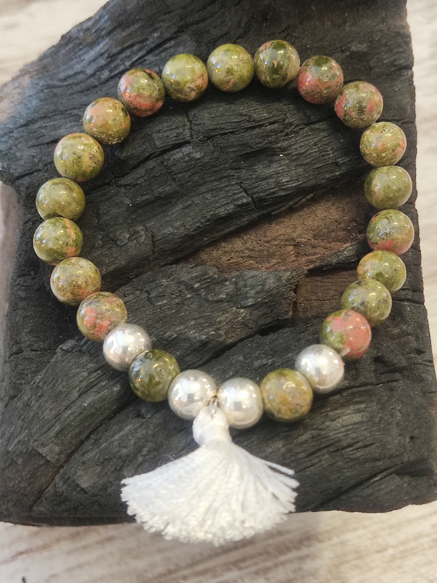 Pulseira de esferas verdes e rosa com contas prateadas e tassel branco