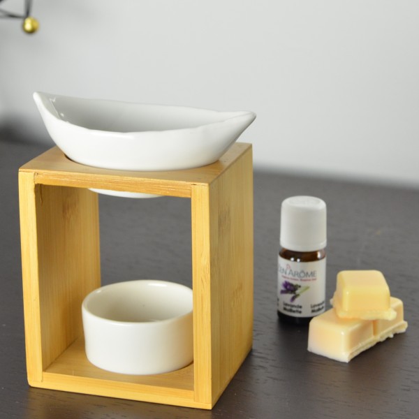 Base de madeira com recipientes cerâmicos brancos, frasco de óleo essencial e cera amarela