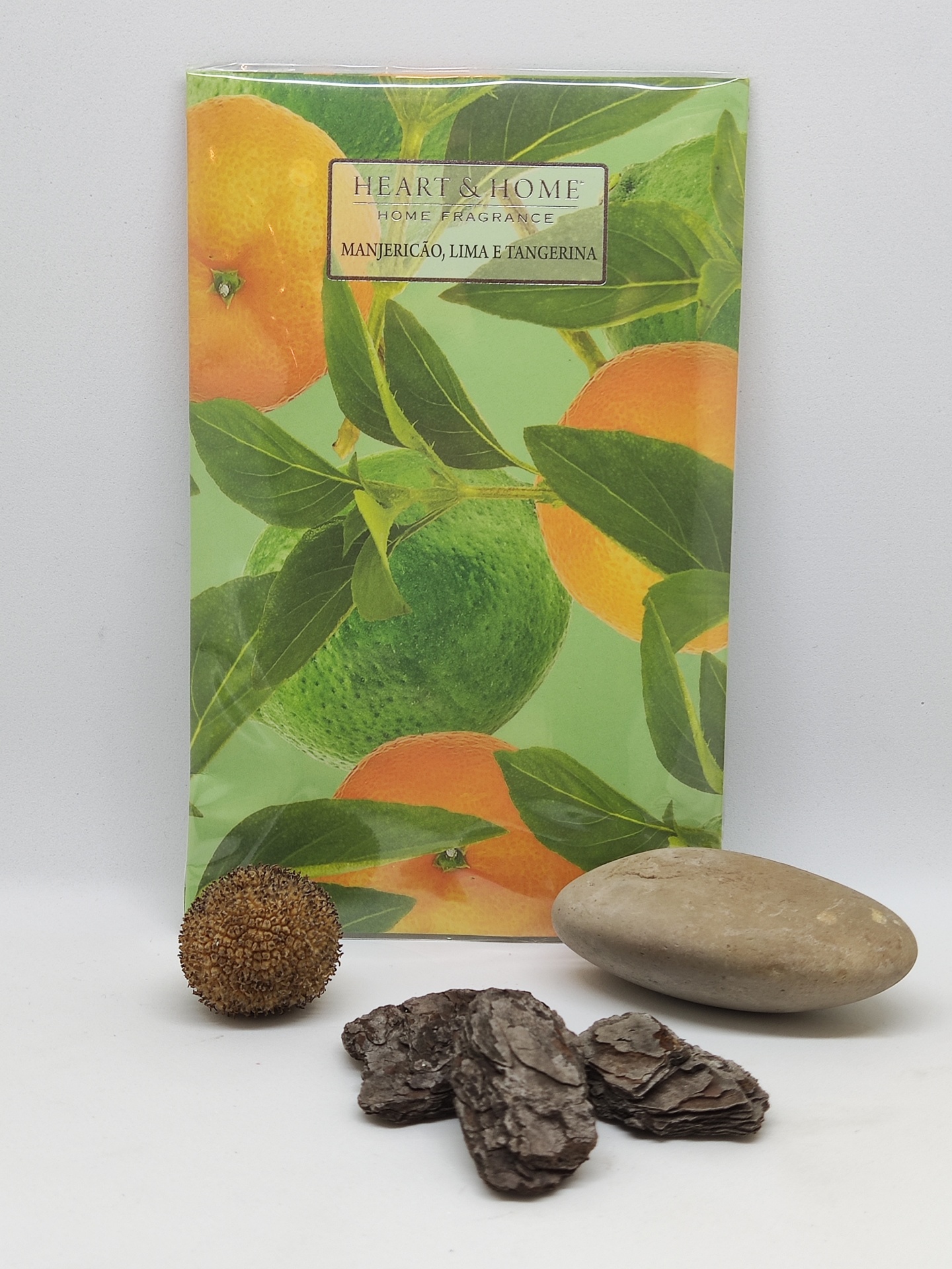 Embalagem de fragrância para casa com ilustração de limas e tangerinas com objetos naturais à frente