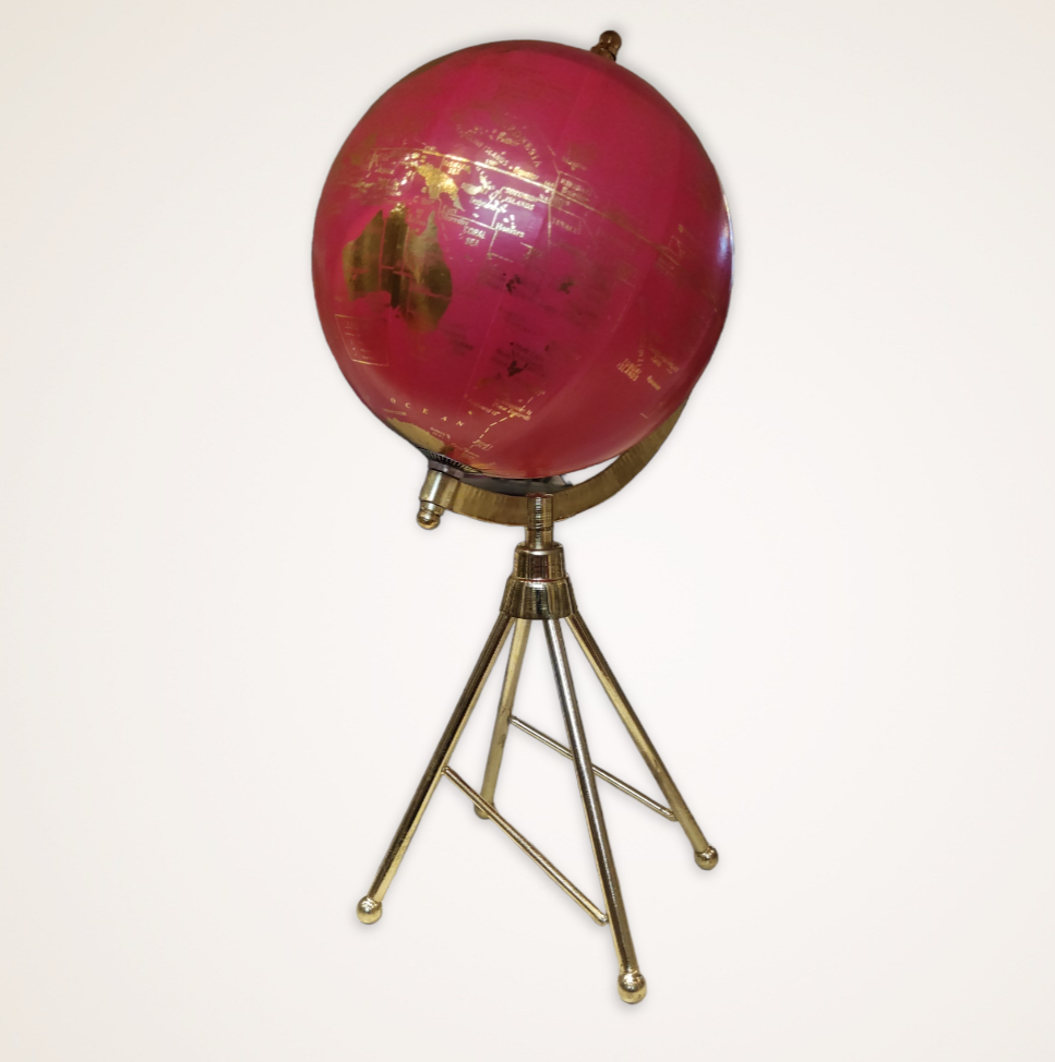 Globo terrestre cor de rosa com tripé dourado