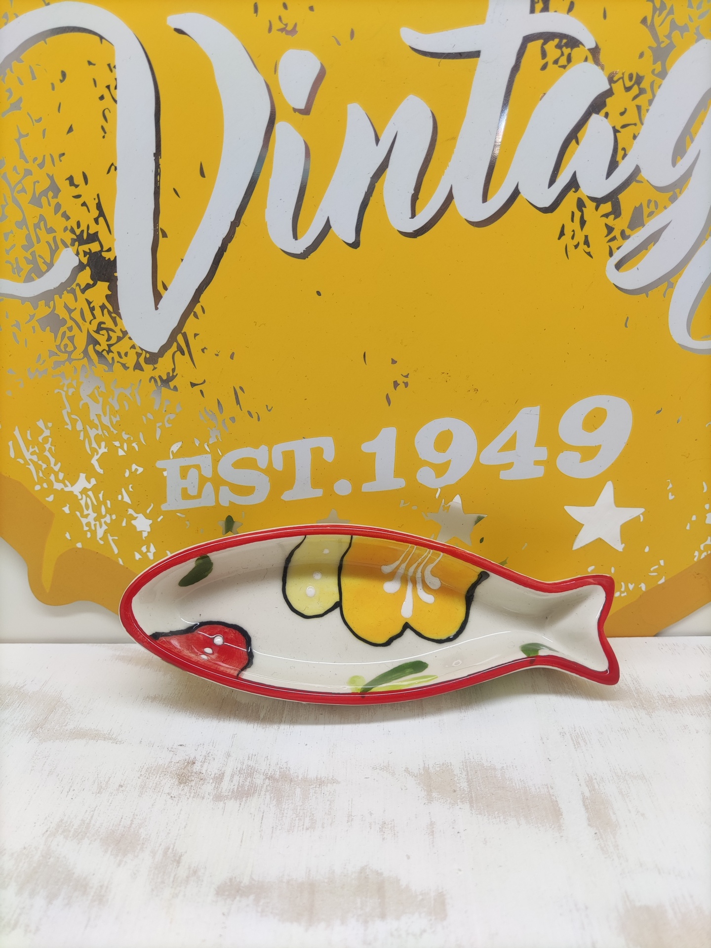 Prato decorativo cerâmico em forma de peixe colorido com fundo amarelo e texto Vintage