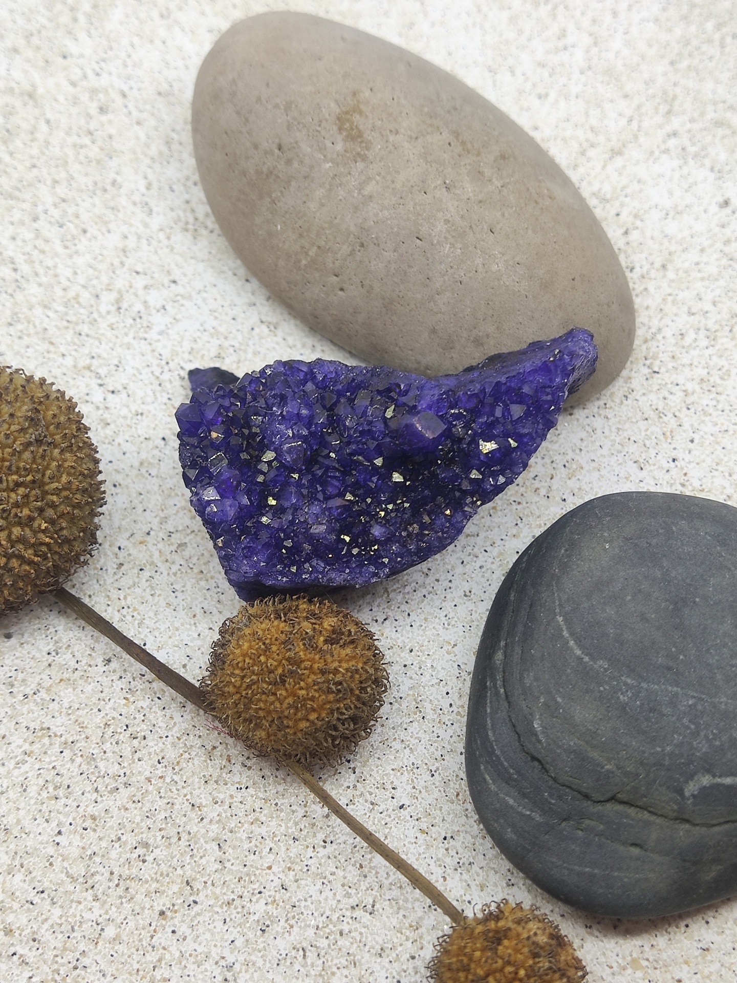 Três pedras e um caule com bolas secas em areia
